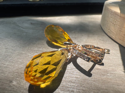 Butterfly-shaped brooch with yellow gemstones on a textured surface